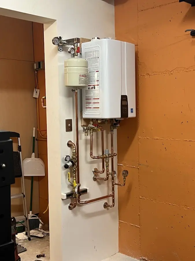 Plumbing technician inspecting water heater connections in Southborough